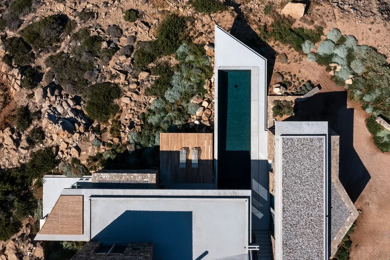 Aerial view of the clustered volumes around a lap pool set into the rocky desert terrain