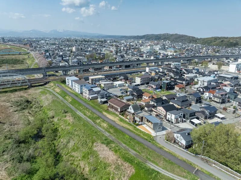 Aerial view of residential neighborhood with elevated highway and distant mountains under clear skies