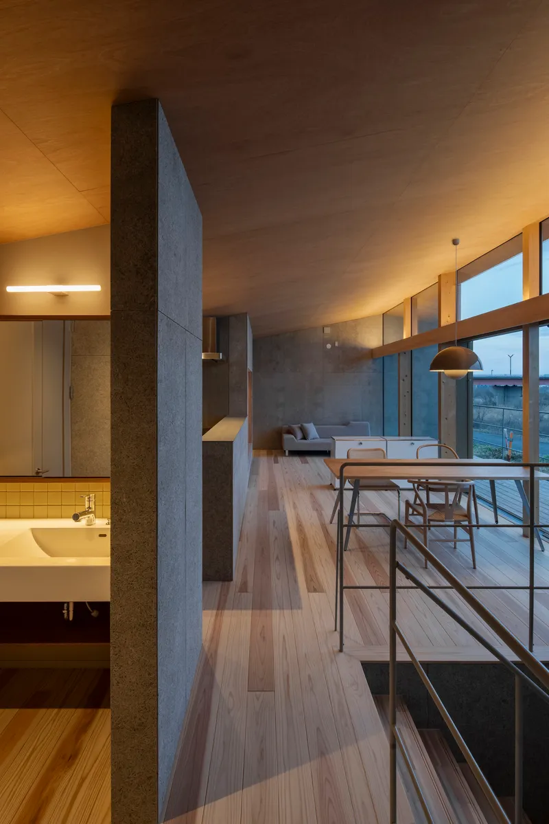 Upper-level corridor with metal railing overlooking the main living area and bathroom below