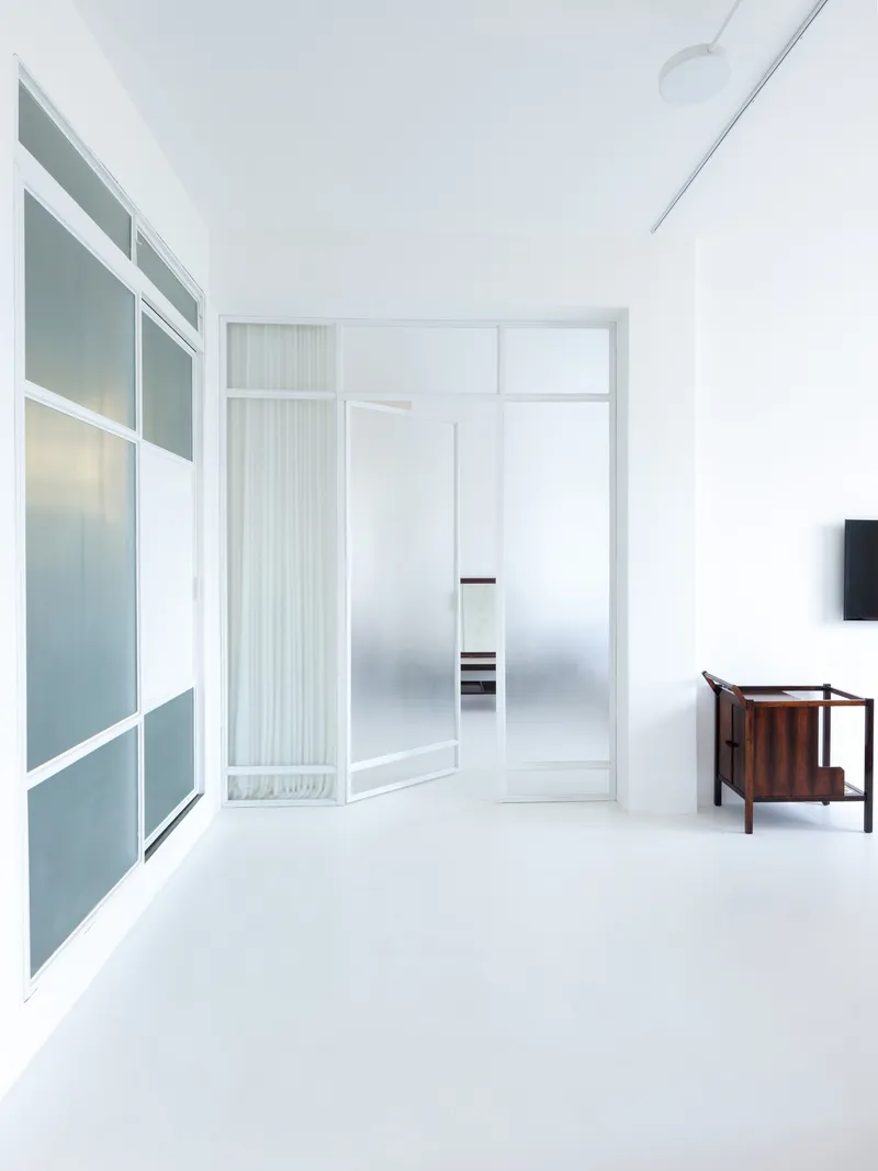 White corridor with translucent glazed partition walls and reeded glass panels