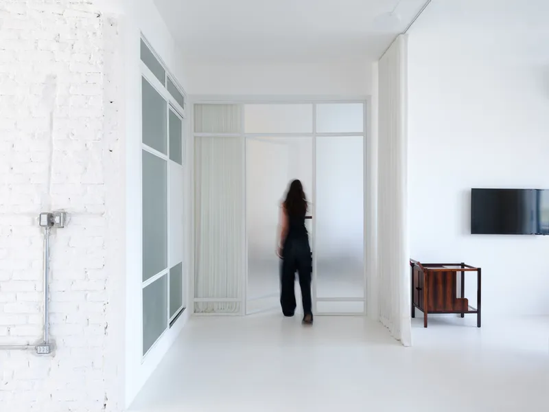 Hallway view showing painted brick wall and figure standing by frosted glass doors