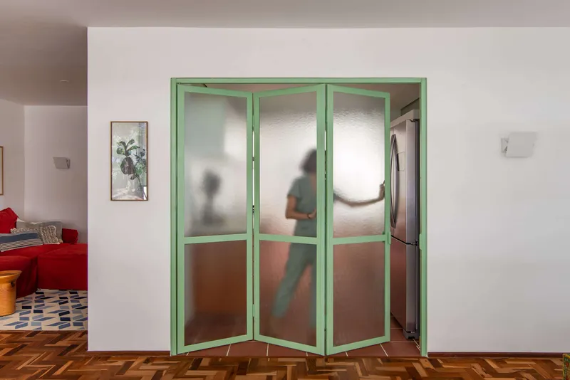 Three-panel folding screen with frosted glass showing silhouettes of people in the kitchen