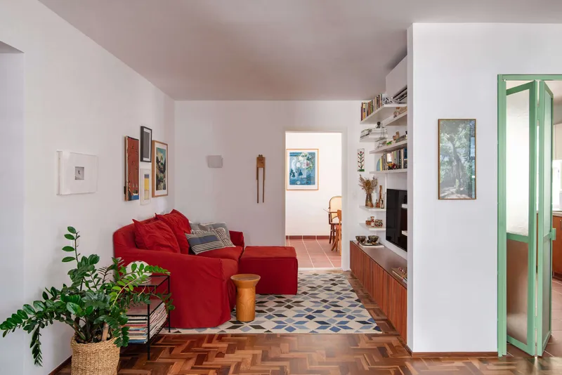 Partial view of the living area showing the transition from herringbone parquet to geometric patterned tile