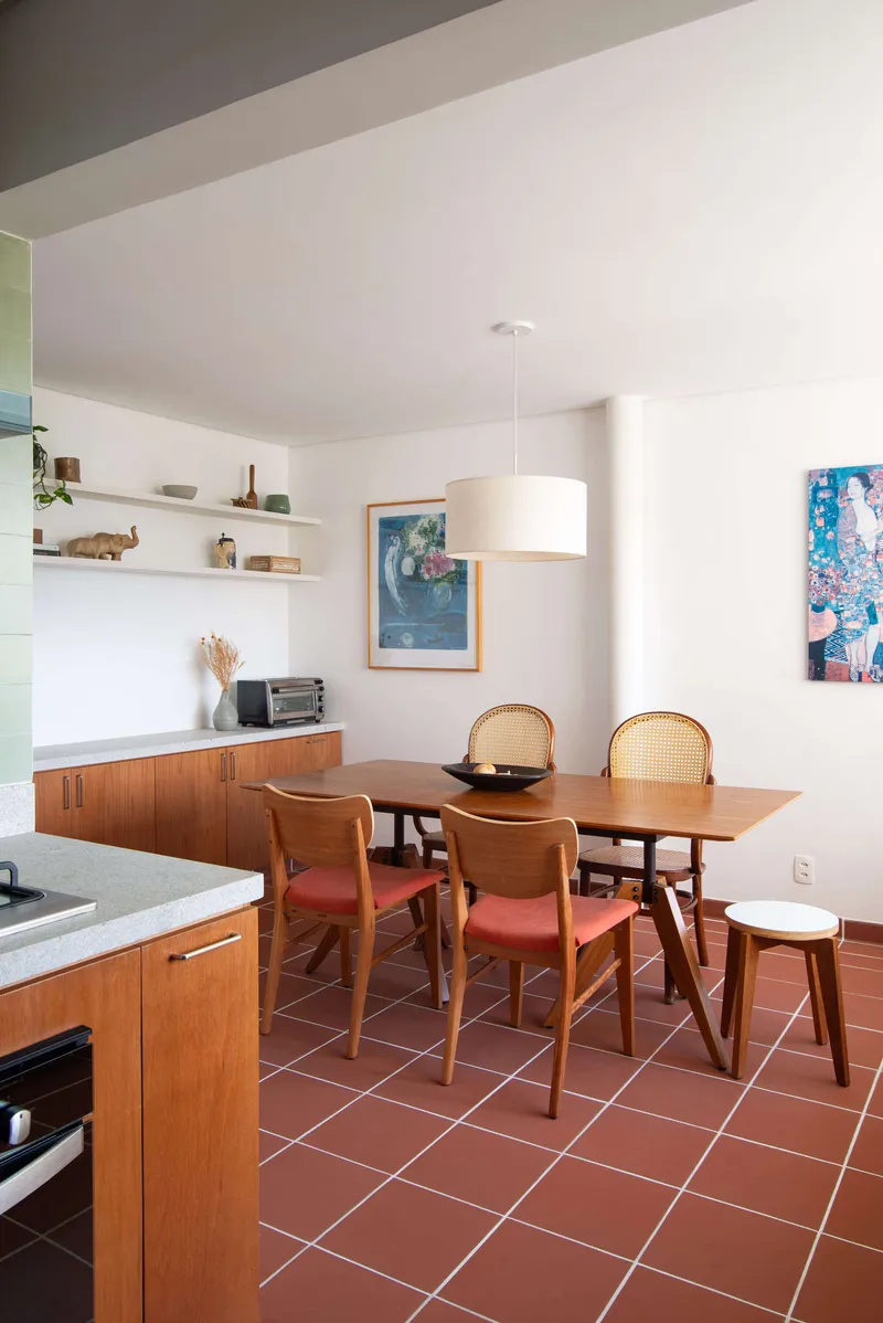 Dining area with terracotta tile floor and timber cabinetry under natural daylight