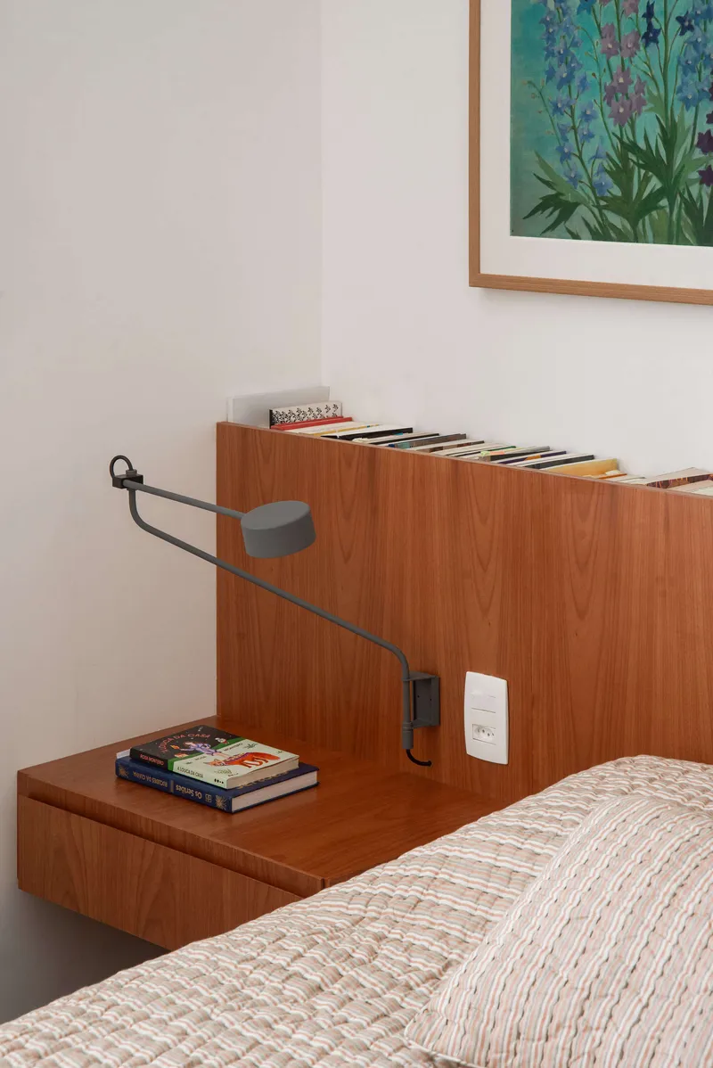 Close-up of timber headboard with integrated nightstand and articulated reading lamp