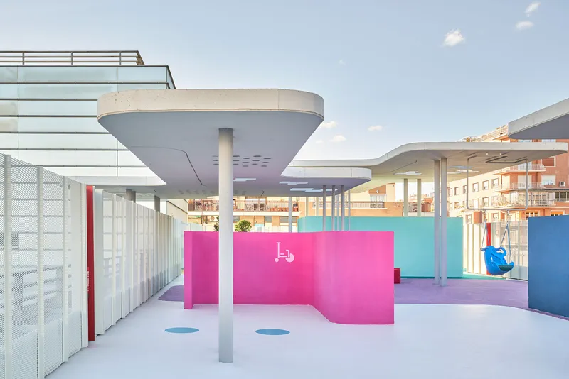 Rooftop terrace with circular canopy columns, pink and blue partition walls, and mesh screening