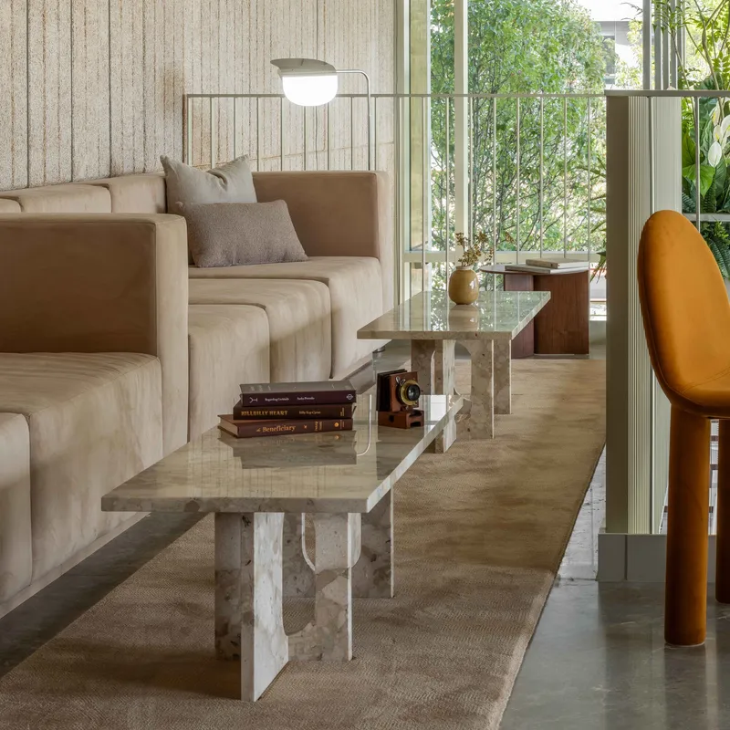 Living area with marble coffee table and view to planted balcony through glazed doors