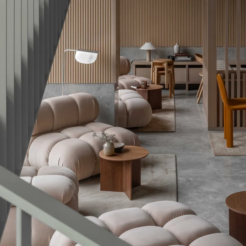 Seating nook with vertical timber slat wall and pale green metal railing in afternoon sunlight
