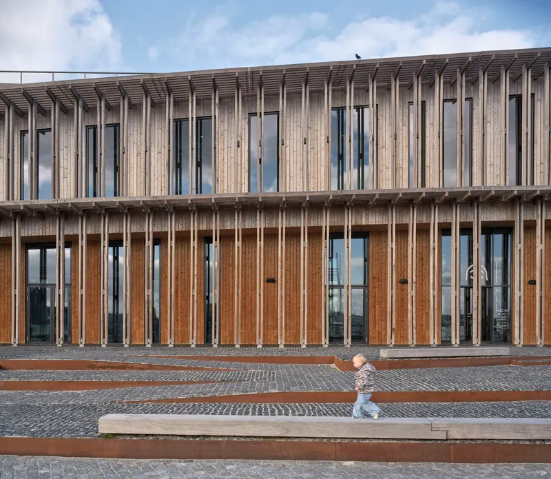 Close-up of the vertical timber screen with inset glazing and a child running along the terrace