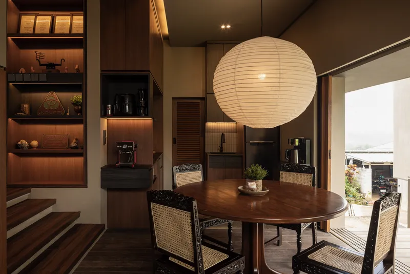 Dining area with spherical paper lantern and open shelving illuminated at dusk