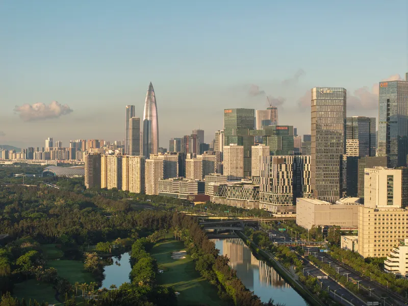 Aerial view of the tower skyline with parkland and canal in the foreground at golden hour
