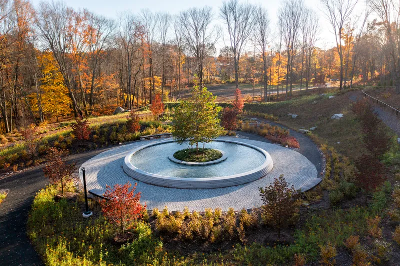 Aerial view of the circular paved plaza with central tree island surrounded by autumn foliage