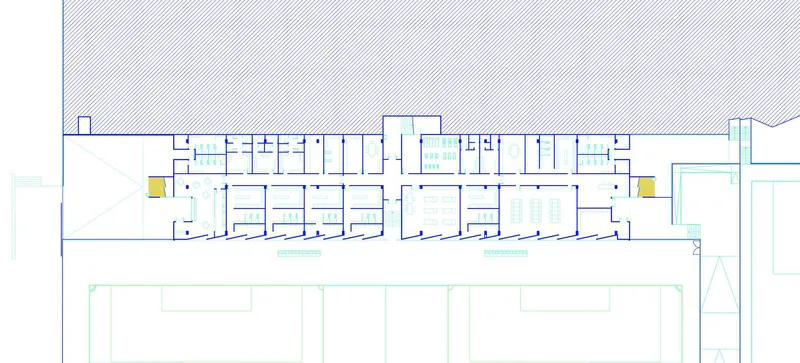 Floor plan drawing showing the linear grandstand building with symmetrical rooms and yellow circulation cores