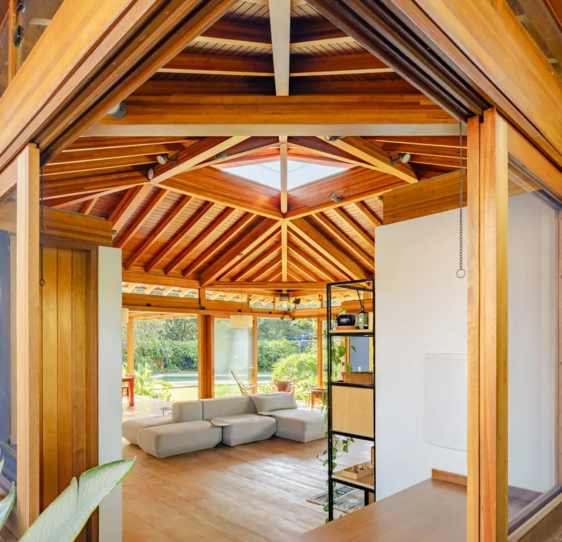 Interior view through doorway to living space with exposed timber roof rafters and skylight above