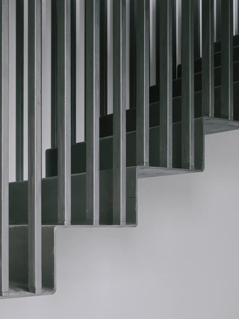 Close-up of vertical timber slat screens forming a rhythmic pattern against a white wall