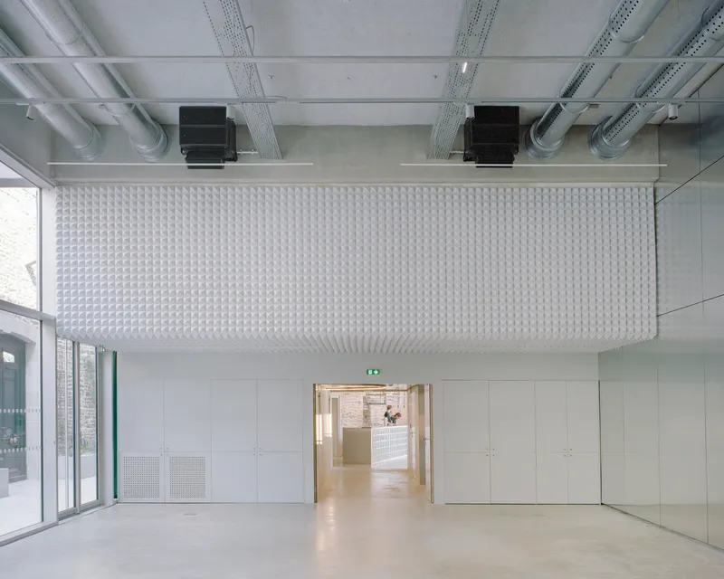 Interior room with textured acoustic ceiling panel, exposed mechanical systems and polished concrete floor