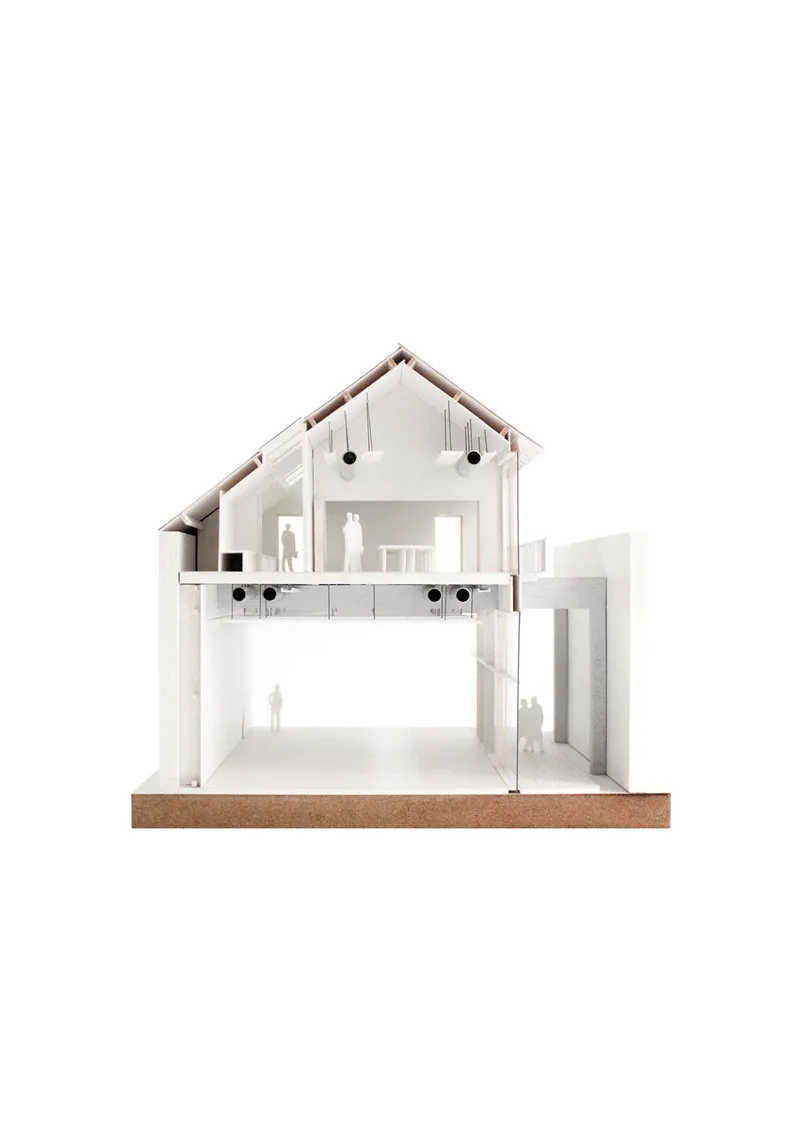 Section model showing a pitched-roof gabled house with two levels and miniature human figures inside
