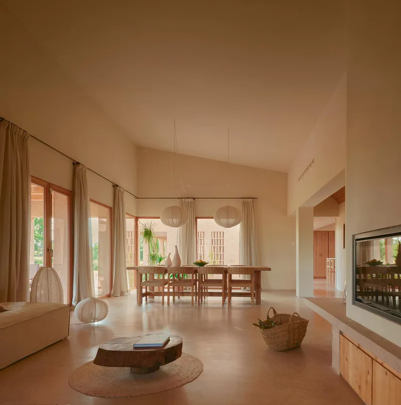 Open-plan living and dining space with timber-framed glazed doors opening to a sunlit courtyard