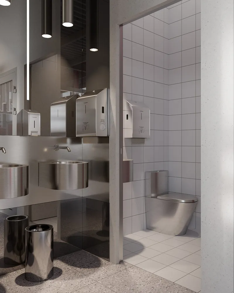 Restroom design featuring stainless steel fixtures and a refined utilitarian aesthetic.