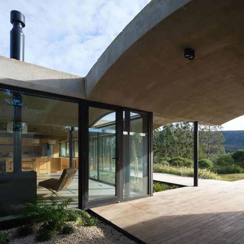 Timber deck terrace with sliding glass doors opening to a landscape of distant hills