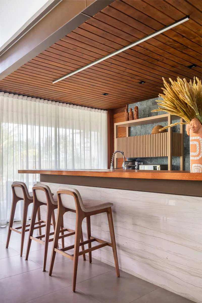Kitchen bar with timber counter and horizontal slatted backsplash beneath a wood slat ceiling