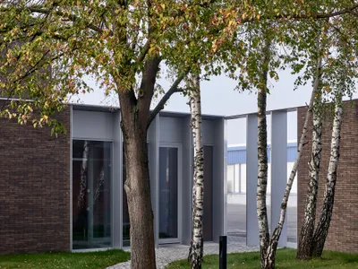 James and Mau Wrap a Polish Industrial Office in Dark Brick and a Birch Forest