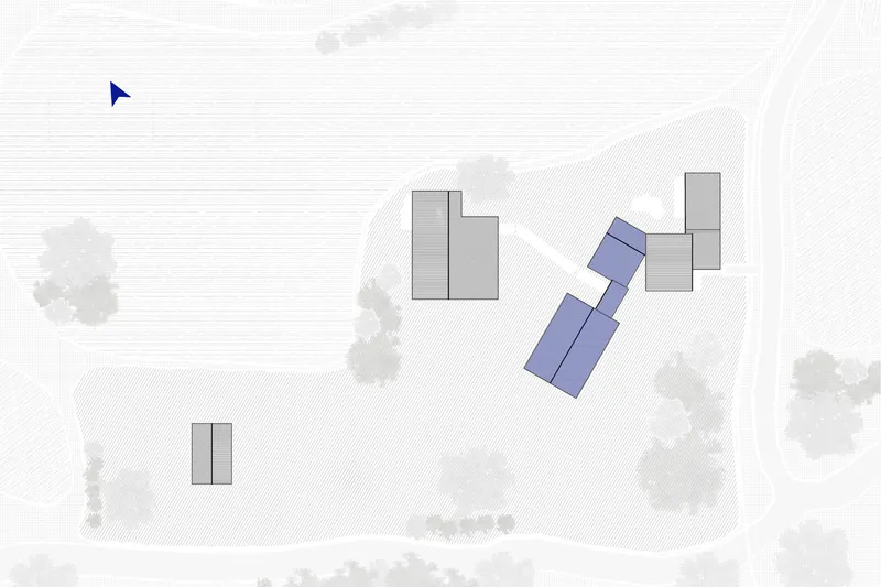 Site plan drawing showing multiple building volumes and trees scattered across sloping terrain