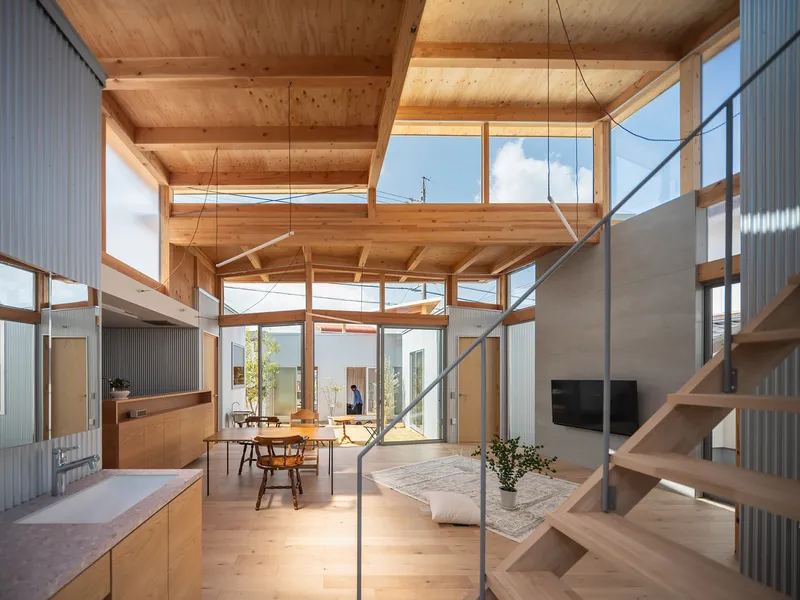 Interior view through the timber frame structure showing layered ceiling planes and clerestory glazing above