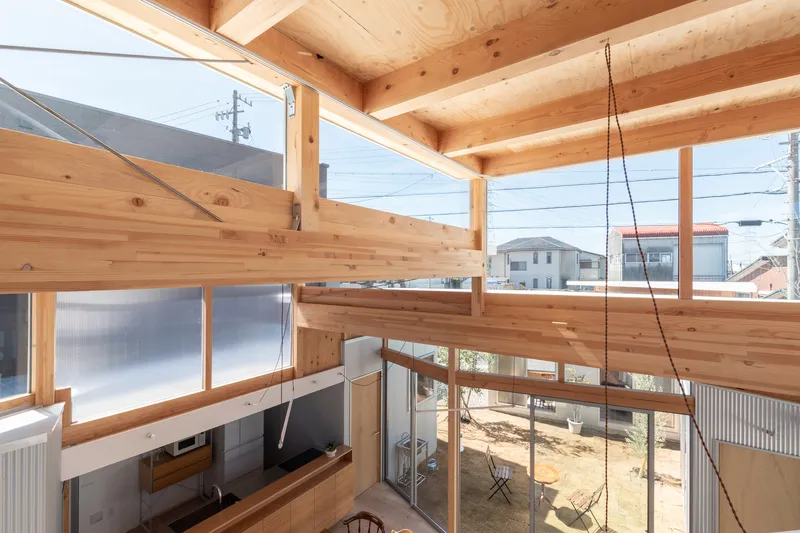 Mezzanine level timber railing overlooking the living area with clerestory windows framing neighboring houses