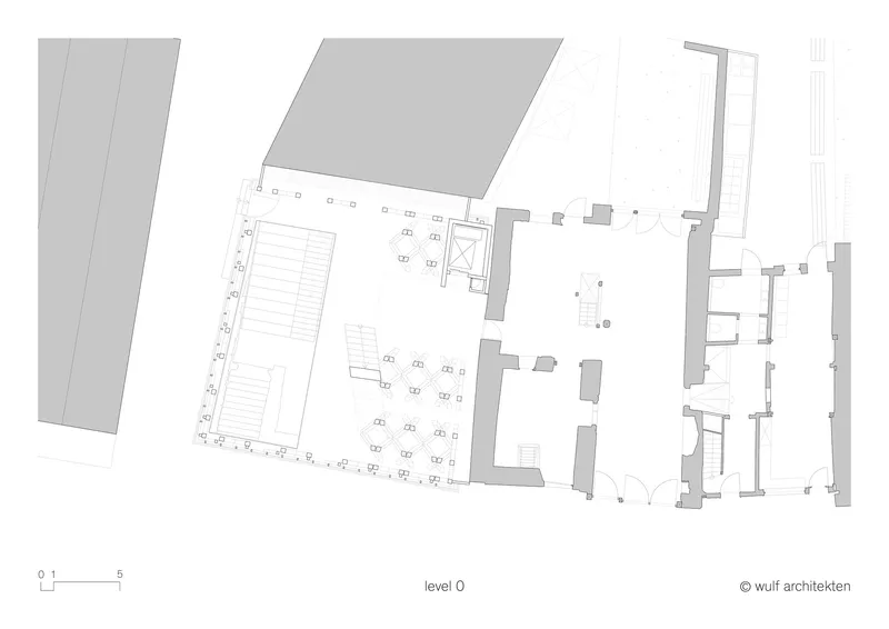 Ground floor plan drawing showing a large angular volume with adjacent courtyard and interior parking rows