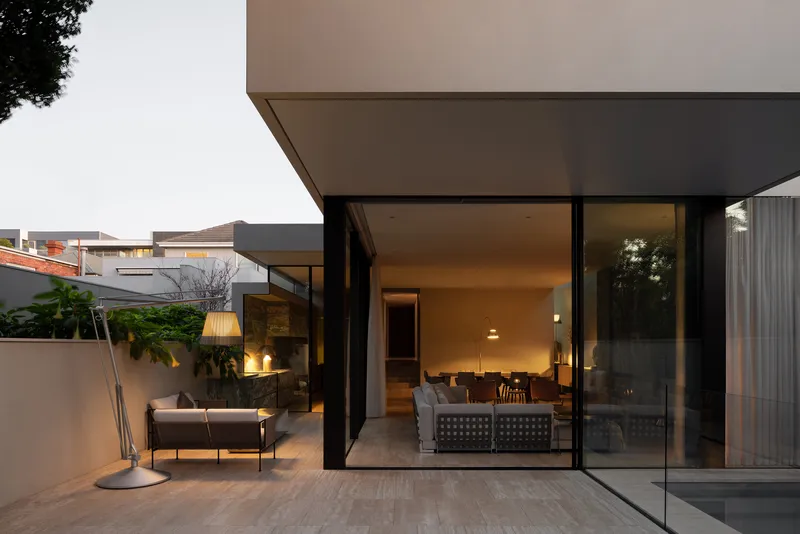 Terrace with full-height glazing opening onto the living room at dusk