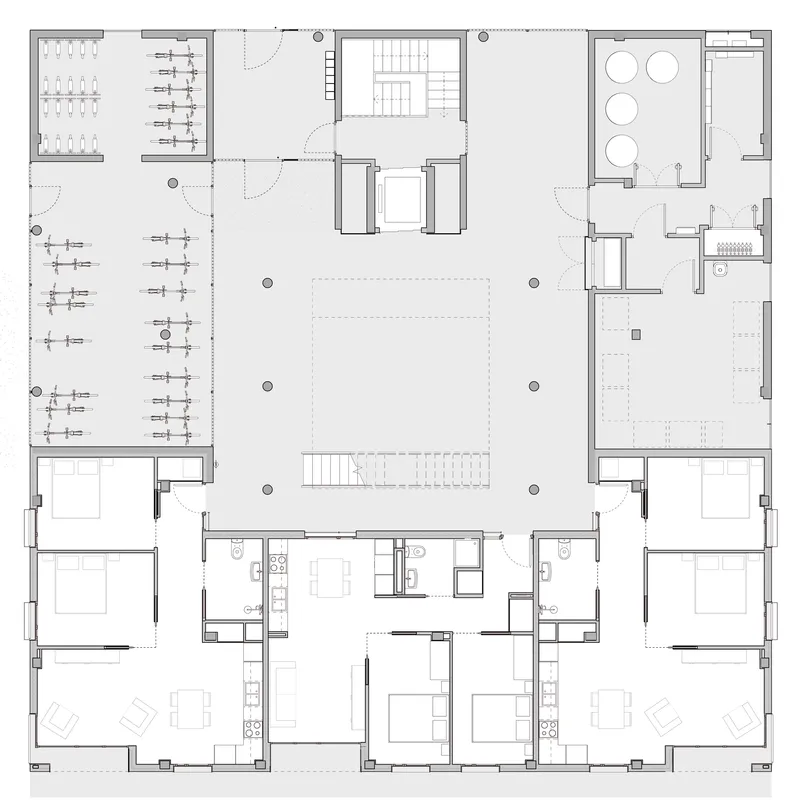 Floor plan drawing showing residential units arranged around a central stairwell and bicycle parking area