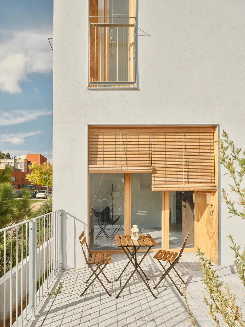 Private terrace with timber louvered screens and folding furniture beneath a small balcony above