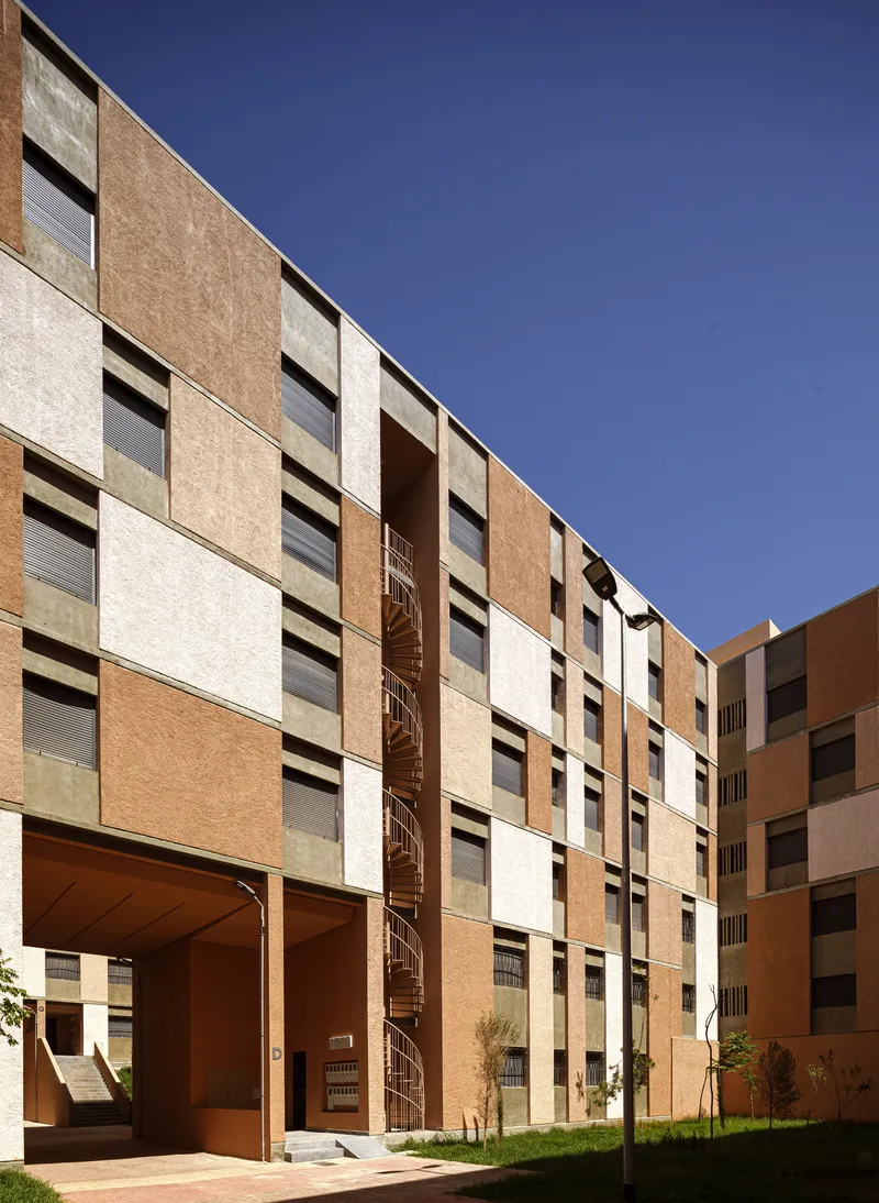 Courtyard elevation showing the panelized facade, spiral staircase, and covered passageway at ground level