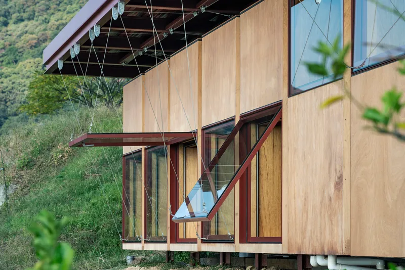 Close-up of the timber facade with operable window panels and cable bracing