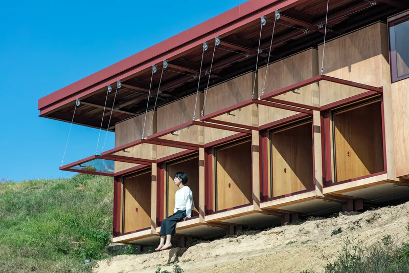 Side view of the cantilevered window bays with a person seated on the threshold