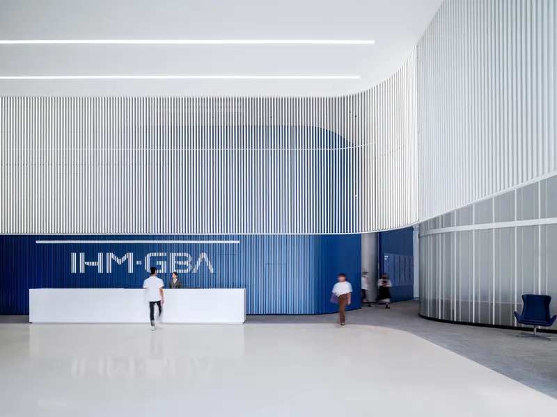 Reception area with white corrugated walls, a blue accent wall and people in motion