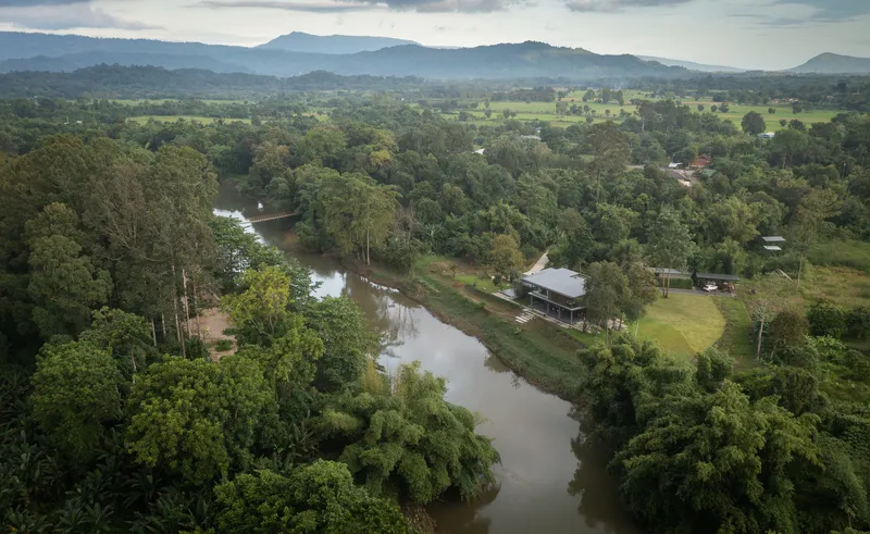 Aerial view of the house nestled among trees along a meandering river