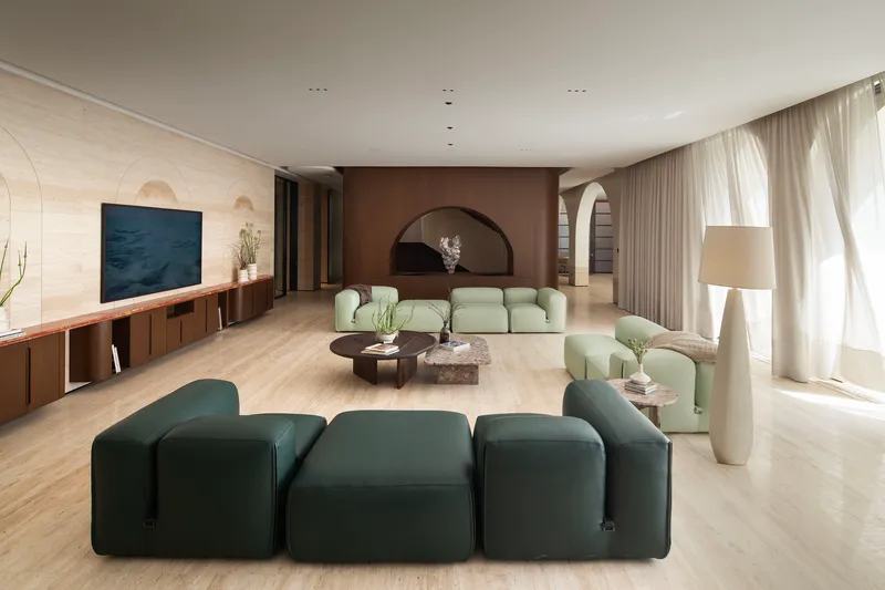 Living area with arched brown-toned wall niche and sheer curtains along the window wall