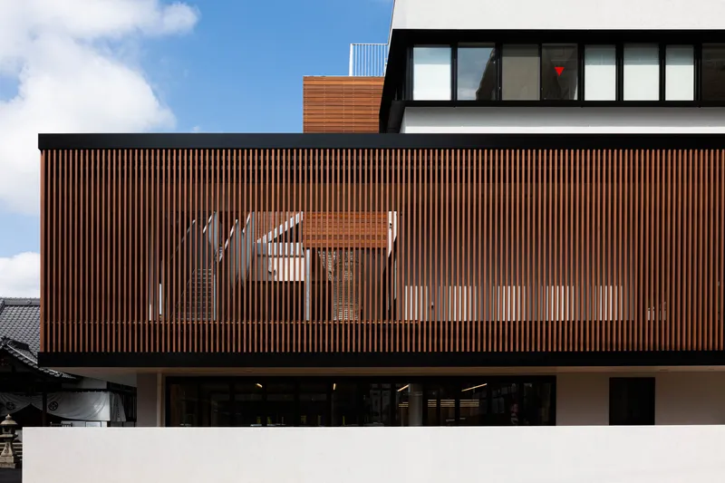 Close-up of the vertical timber slat screen with signage visible behind