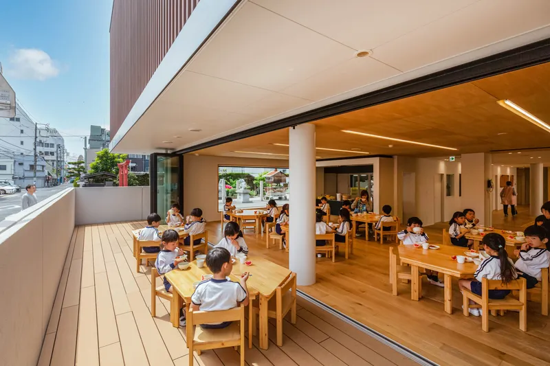 Open dining area with sliding glass doors to a timber deck and children seated at tables