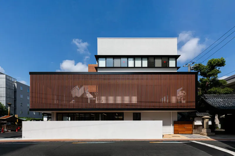 Street view of the layered facade with vertical timber screening on the middle level