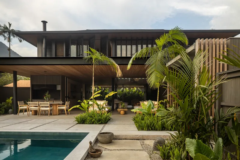 Poolside terrace with planted beds beneath the overhanging timber soffit and upper floor balcony