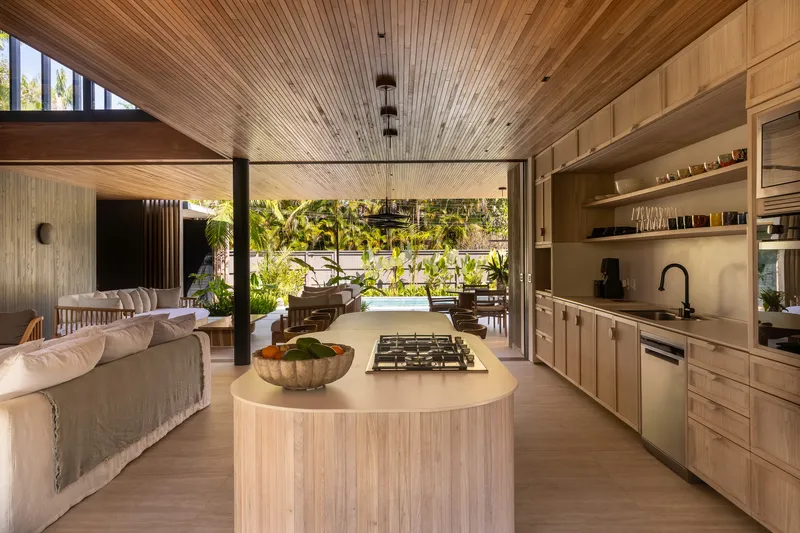 View through open-plan kitchen and living space toward a planted outdoor terrace