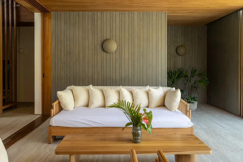 Seating area with ribbed timber wall panels and circular wall sconces in soft light
