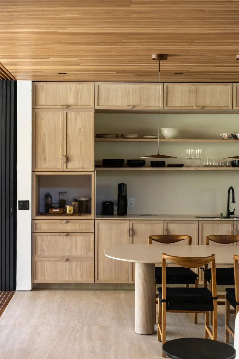 Kitchen cabinetry detail showing recessed appliance niche and floating open shelves