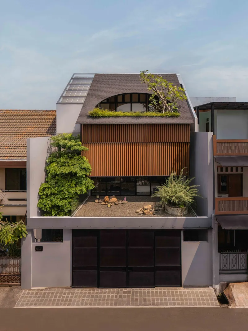 Front elevation showing curved shingle roof, timber screen wall, and planted terrace below