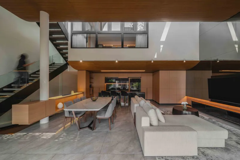 Double-height living room with timber ceiling, open stair, and clerestory windows above