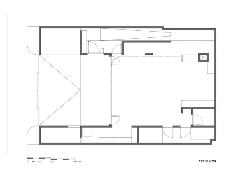First floor plan drawing showing open living area with triangular void and service rooms
