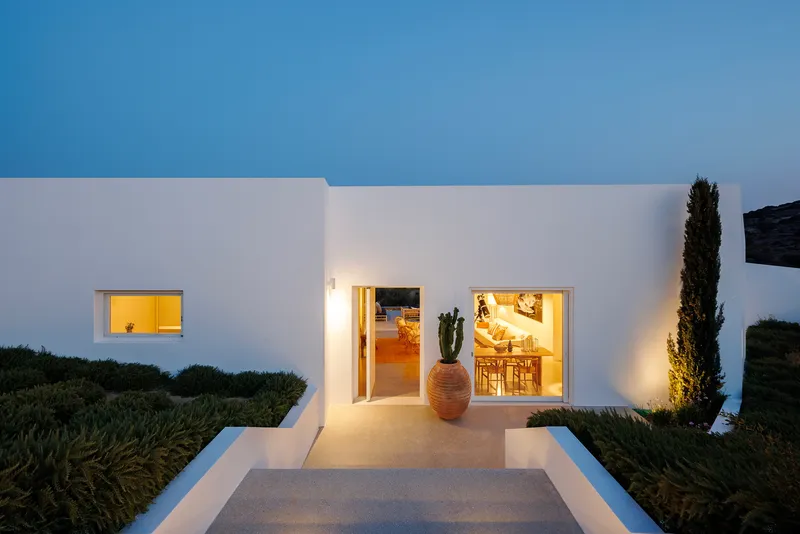 Entry path at dusk with a terracotta pot flanked by cactus and cypress